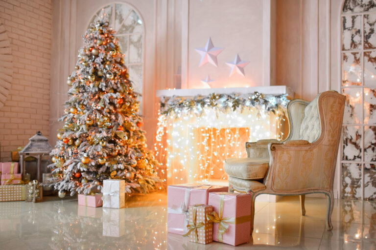 White fireplace decorated with yellow garland and Christmas tree